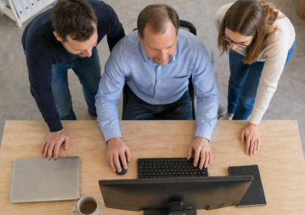 Geschäftsführer von DatenAnker Marco Kraszczynski und sein Team vor einem Rechner